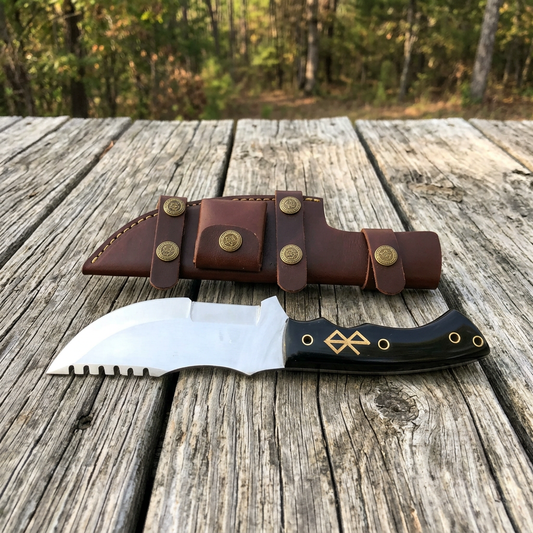Tracker knife with black micarta handle and sheath on rustic cabin boards