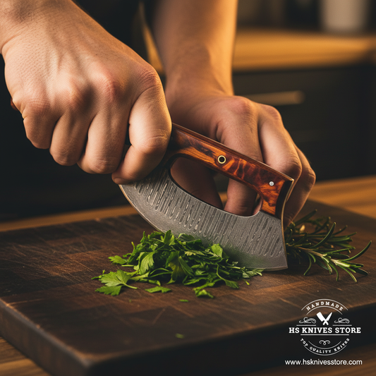 Hands using Damascus steel ulu knife with tortoiseshell resin handle in rocking chopping motion on dark wooden cutting board lifestyle shot