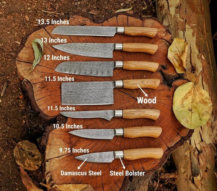 Seven kitchen knives and a steel bolster arranged on a cut tree stump outdoors, with overlaid size and material labels including 13.5 inches, 13 inches, 12 inches, 11.