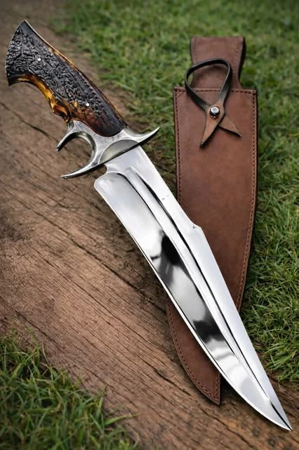 Handmade Bowie knife with stag horn handle and leather sheath on wood