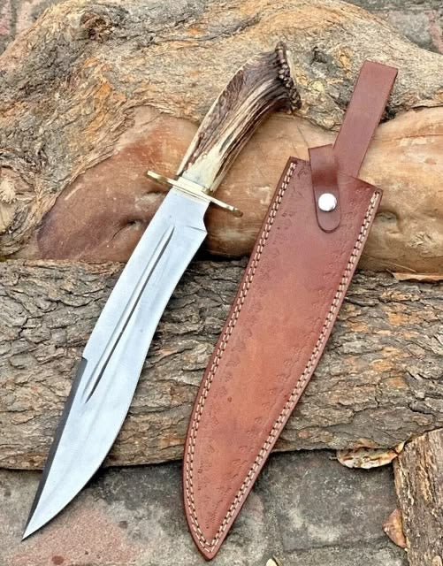 Handmade D2 steel Bowie knife with antler crown handle and leather sheath on rock