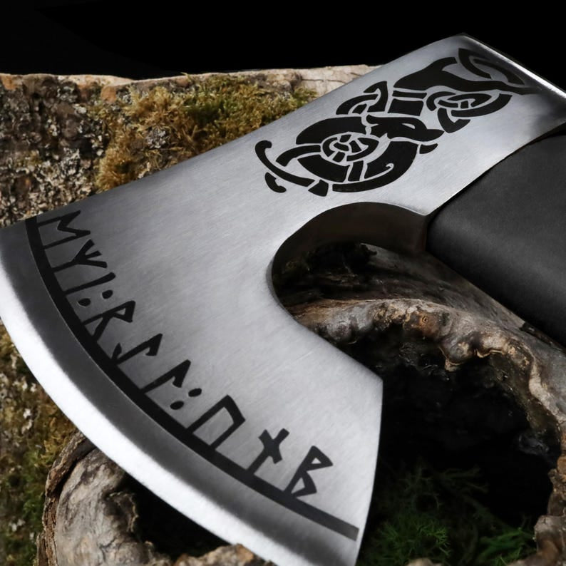 Decorative axe head with tribal design and runes on a wooden background