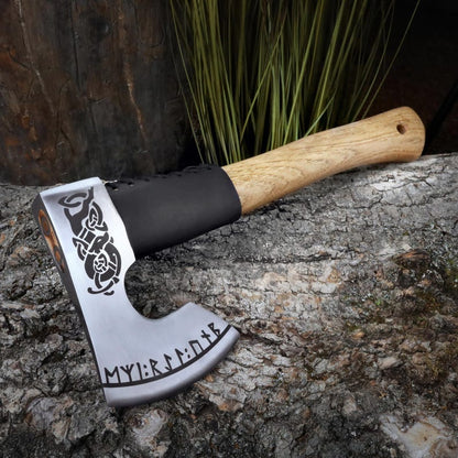 Axes with decorative blade and wooden handle on a stone surface
