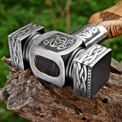 Decorative hammer with intricate designs on a wooden surface