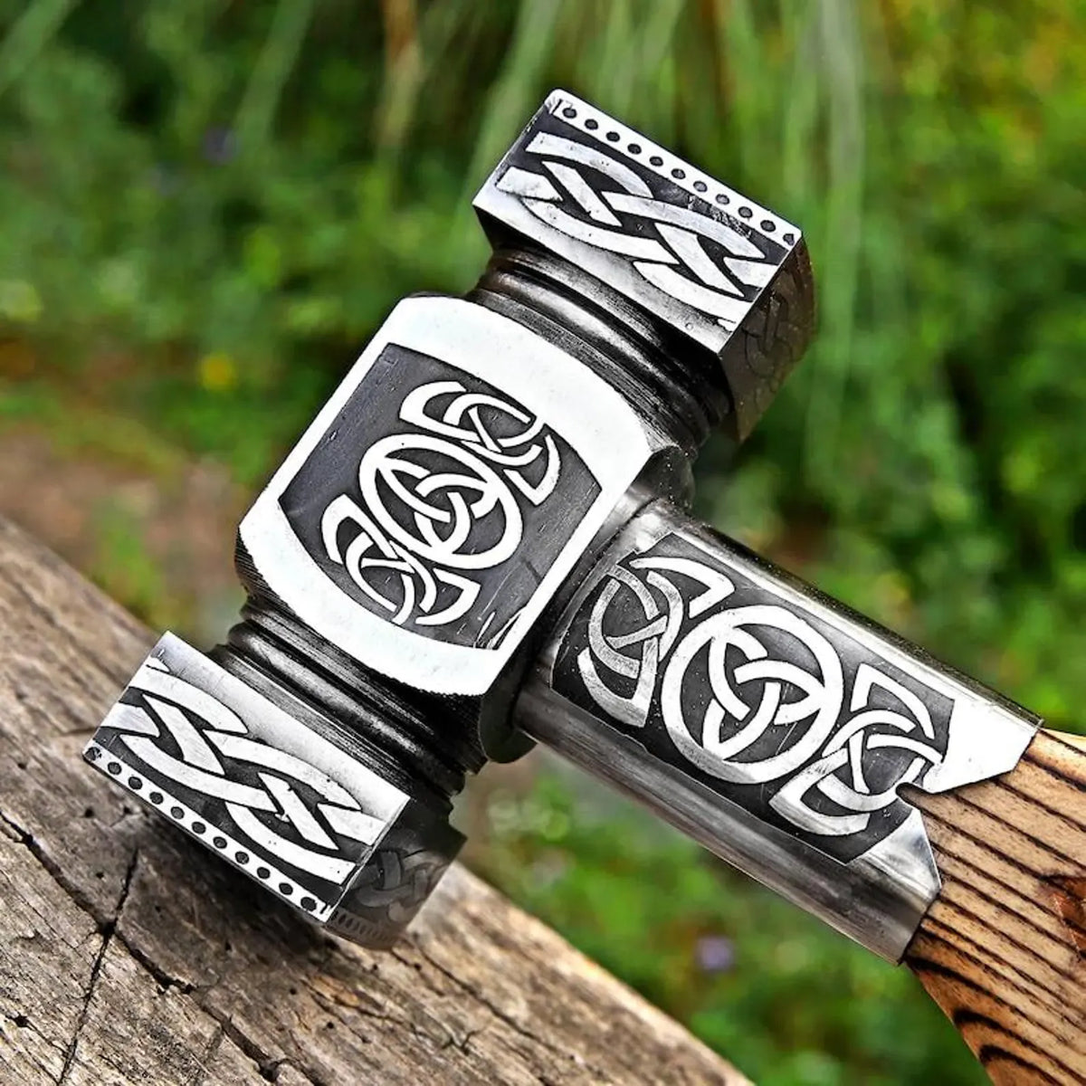 Decorative hammer with Celtic knot designs on a wooden surface