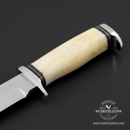 Macro view of natural bone handle with double chrome steel bolster front guard and rear cap and black spacers on J2 steel hunting knife