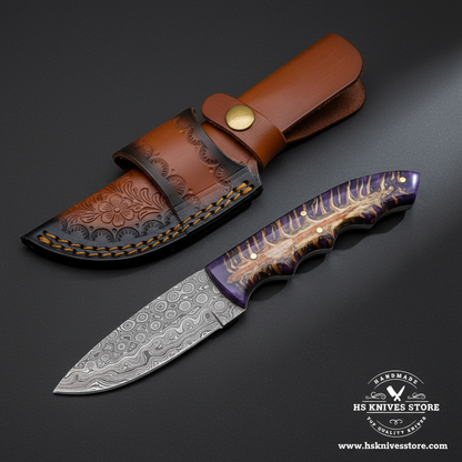 Damascus knife with purple resin pine cone stag handle and tan floral leather sheath mirror view on dark charcoal background