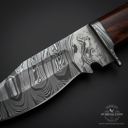 Close-up macro of hand forged Damascus steel Bowie blade and Damascus bolster showing matching swirling pattern detail