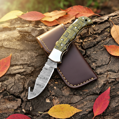 Damascus folding knife flat lay with leather sheath on rustic wood surface with autumn leaves