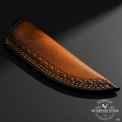 Close-up of two-tone leather knife sheath with tan orange front and dark brown black back panel and embossed scallop pattern macro detail