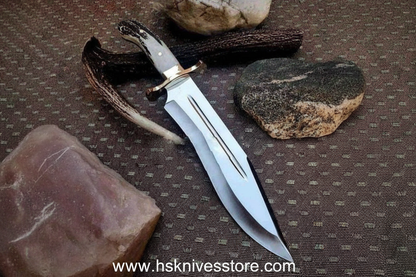 Handmade Bowie knife flat lay on rustic wood with leather sheath and antler accessories www.hsknivesstore.com