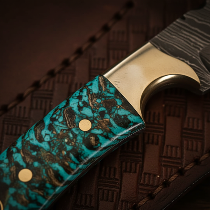 Close-up macro of turquoise green resin handle with brass bolster and brass pins on Damascus skinner knife