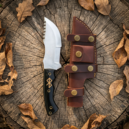 D2 tracker knife and sheath displayed on a stump with dry leaves
