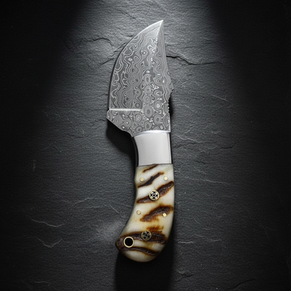 Damascus skinner knife vertical shot on dark slate background blade pointing up