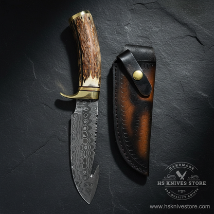 Vertical luxury shot of Damascus steel gut hook hunting knife stag antler handle on dark slate background with dark black leather sheath