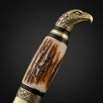 Close-up macro of white burned bone handle with hand-etched detailing, engraved brass bolster and eagle head pommel