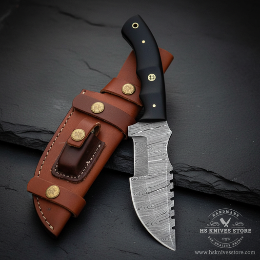 Vertical luxury shot of Damascus steel tracker knife black micarta handle on dark slate background with cognac leather sheath