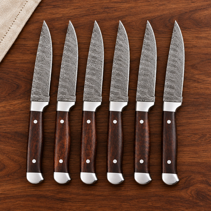 Front view of six Damascus steak knives with brown wood handles on a walnut dining table