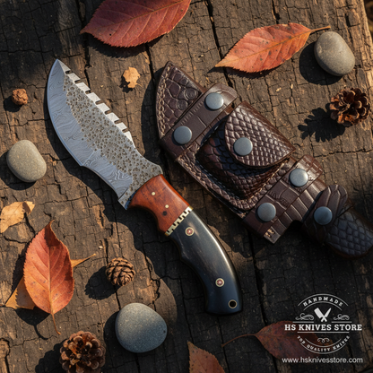 Damascus steel tracker knife buffalo horn handle flat lay rustic dark wood surface with autumn leaves and pine cones