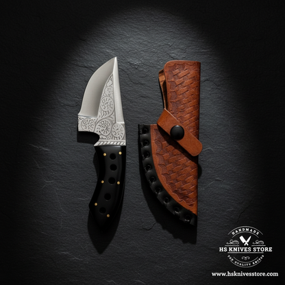 J2 steel skinner knife displayed vertically on dark slate with black resin handle and tan basket weave leather sheath luxury shot