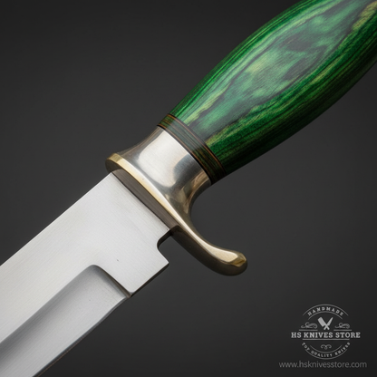 Close-up macro of green pakkawood handle scales with layered green grain silver bolster and silver crossguard with brass clip quillon