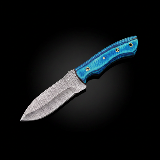 Handmade Damascus steel skinner knife with blue pakkawood handle on black studio background left facing dramatic spotlight