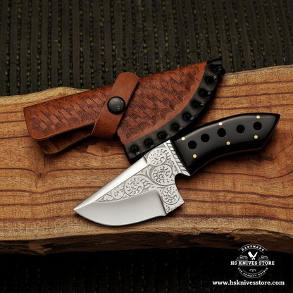J2 steel skinner knife with black resin handle and tan basket weave leather sheath on dark charcoal background studio shot