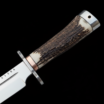 Close up macro shot of dark stag horn handle and steel crossguard Bowie knife