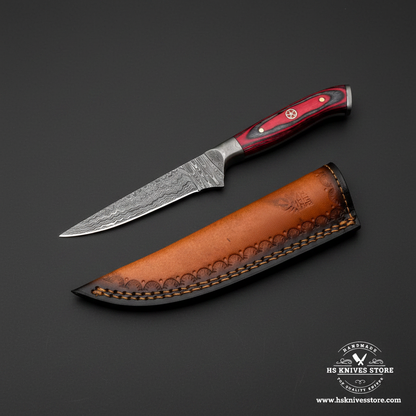 Damascus skinning knife with red hardwood handle and two-tone leather sheath mirror view on dark charcoal background