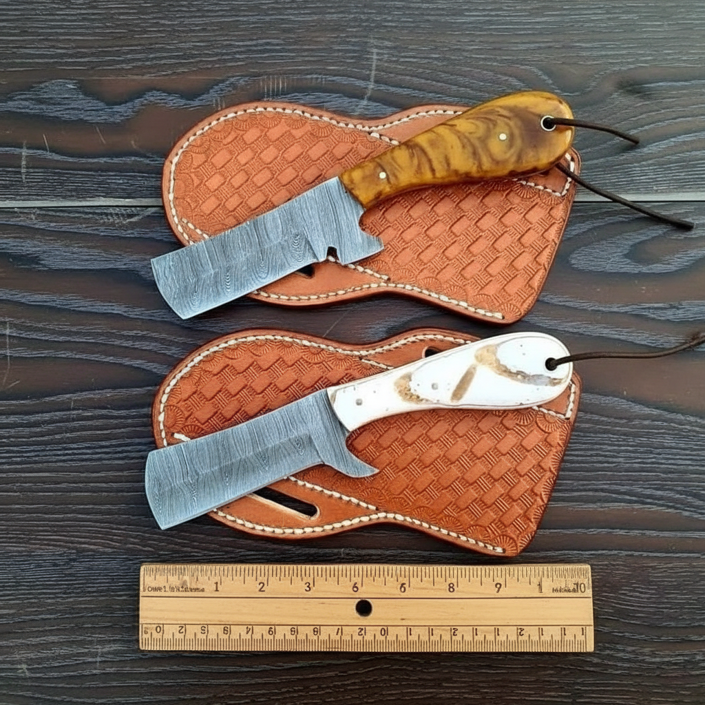 Top-down display of two custom Damascus Bull Cutter Knives and separate leather sheaths on a walnut table