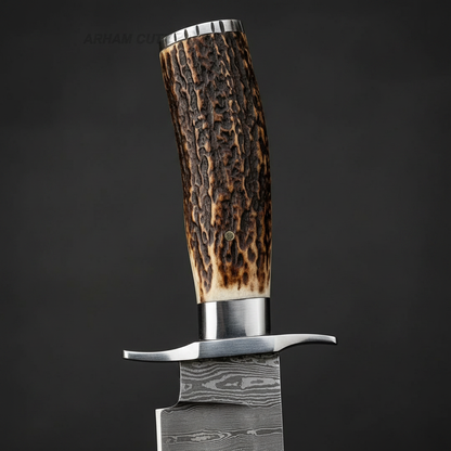 Close-up macro of natural stag horn handle and steel cross guard double quillon on Damascus Bowie knife