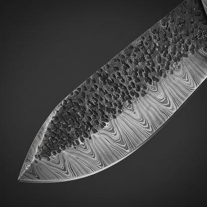 Damascus steel blade close-up showing hammered spine texture and flowing layered Damascus pattern