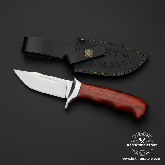 J2 steel skinner hunting knife with rosewood handle and black embossed leather sheath on dark charcoal background studio shot