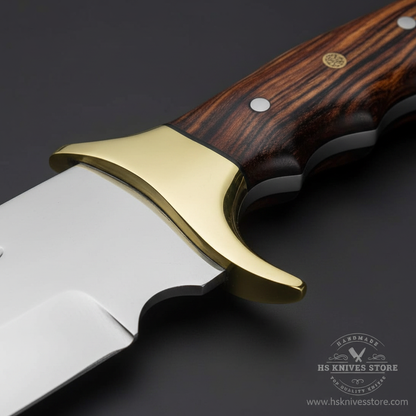 Close-up macro of dark rosewood handle with warm reddish-brown grain and black spacer layers and large polished gold brass bolster