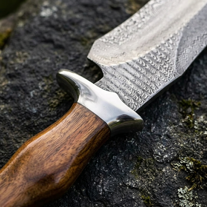 Solid steel guard detail between rosewood handle and patterned Damascus blade