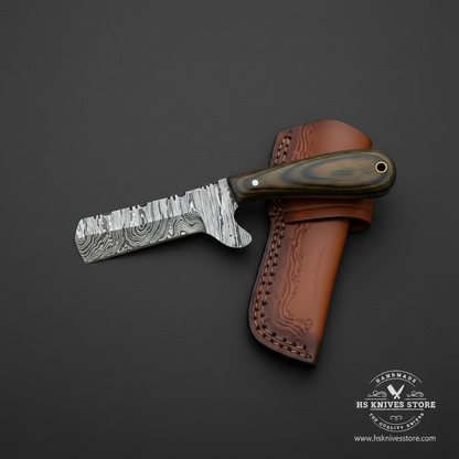Damascus bull cutter cowboy knife with dark pakkawood handle and tan leather sheath studio mirror view facing left dark background