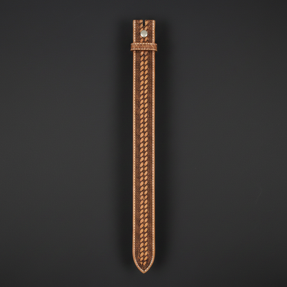 Hand-tooled western cowboy leather belt hanging vertical charcoal background full length