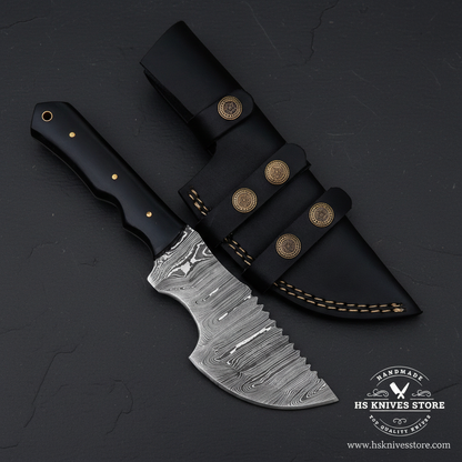 Vertical luxury presentation of a black Micarta Damascus tracker hunting knife on dark slate