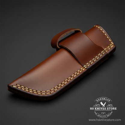 Macro close-up of medium brown leather horizontal carry sheath showing belt loop tab at top and gold stitching along edges