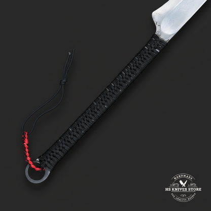 Close-up of black paracord handle wrap, full tang detail, lanyard hole, and red black lanyard