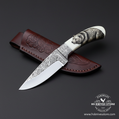 D2 steel engraved skinner knife with floral scroll blade bear engraved white resin handle and dark burgundy leather sheath studio dark charcoal right facing