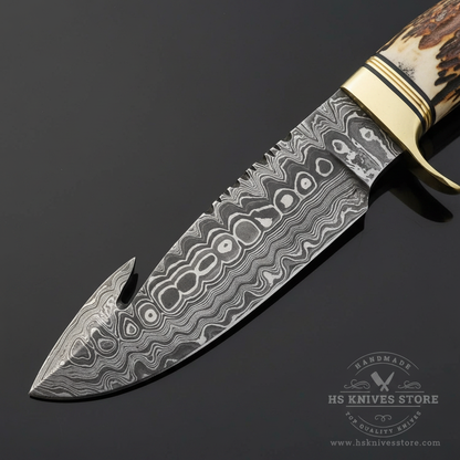 Close-up macro of Damascus steel gut hook hunting blade showing bold swirling eye wave Damascus pattern and gut hook at tip clearly visible