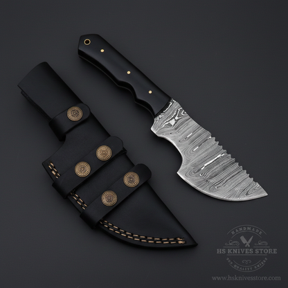 Black Micarta Damascus tracker hunting knife and black leather sheath on dark charcoal background