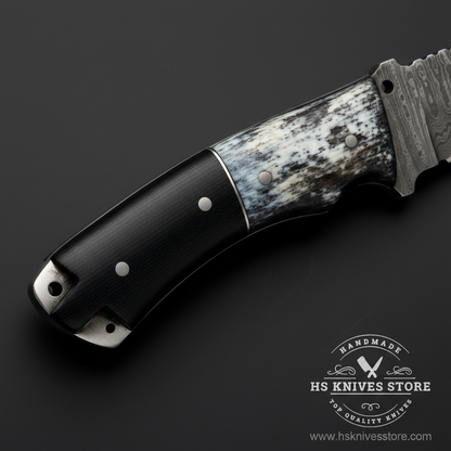 Macro close-up of two-tone knife handle showing dark black micarta scales with white cream bone spacer accents and steel pins