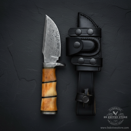 Vertical luxury shot of Damascus steel skinner knife camel bone handle on dark slate background with black leather sheath