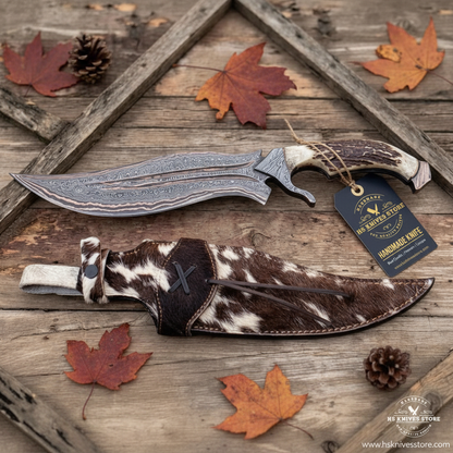 Damascus copper Bowie knife stag handle flat lay on dark rustic wood with HS Knives Store hang tag attached autumn leaves pine cones