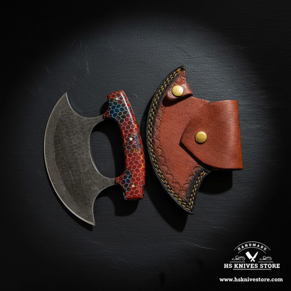 Damascus steel ulu knife displayed vertically on dark slate with honeycomb resin handle and crescent leather sheath luxury shot