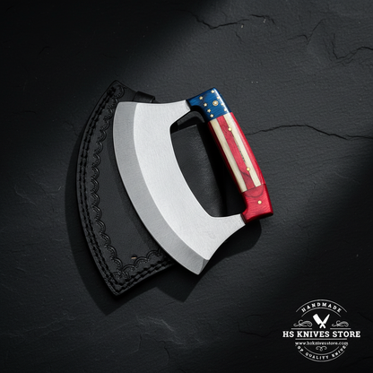 D2 steel ulu knife with American flag handle and black leather sheath displayed vertically on dark slate luxury studio background