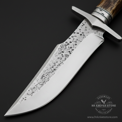Close-up macro of hand forged Bowie blade showing hammered textured finish polished edge wide fuller and double crossguard