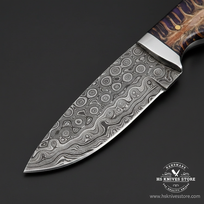 Close-up of Damascus steel knife blade showing unique circular swirling ladder Damascus pattern and silver bolster macro detail